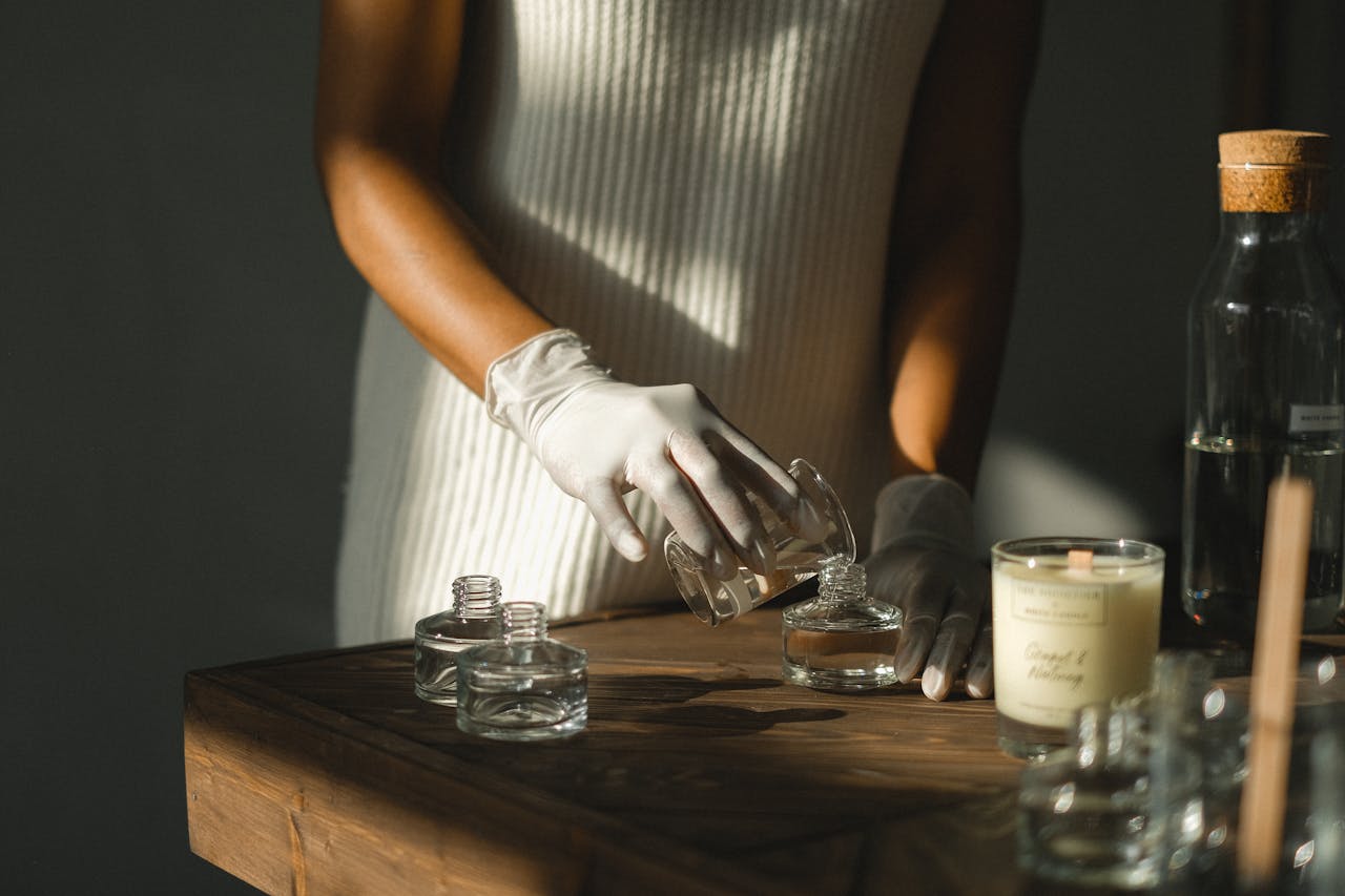 Nahaufnahme einer Person mit weißen Handschuhen, die eine Duftessenz untersucht – Symbolbild für die Herstellung und Analyse hochwertiger Parfums mit besonderen Inhaltsstoffen wie Ambra (Walkotze).