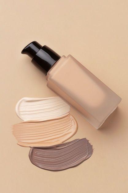 Make-up-Foundation in einer Flasche mit Pumpspender, daneben drei verschiedene Farbtöne als Swatches auf beigem Hintergrund. Ideal zur Darstellung von Foundations für unterschiedliche Hauttypen und -töne.